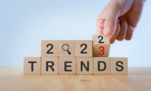2023 trend concept. Hand flip wooden cube change year 2022 to 2023. Beautiful white background, copy space. Used for the banner trend concept of the new year for monitoring new business opportunities.